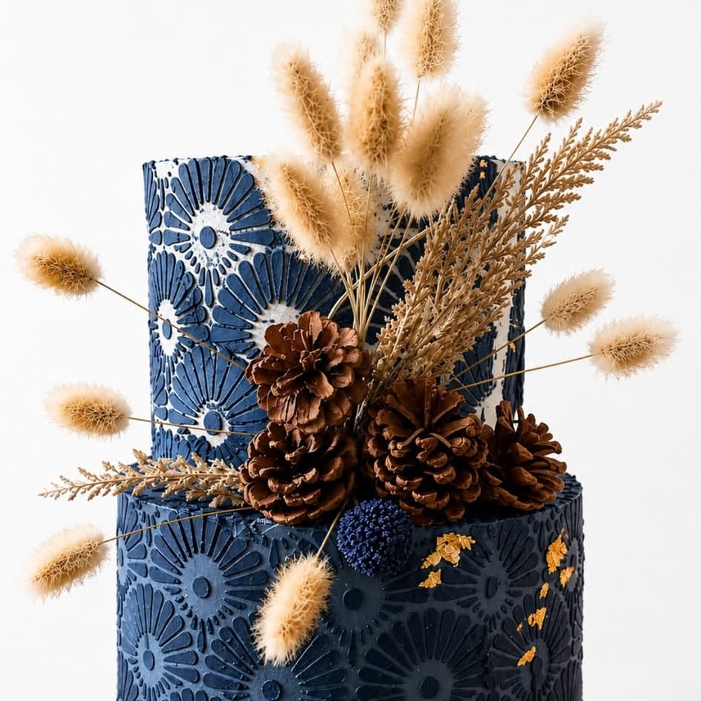 Torta azul de dos pisos con pampas, piñas y detalles dorados